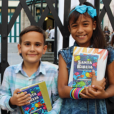 Smiling children with Scripture resources