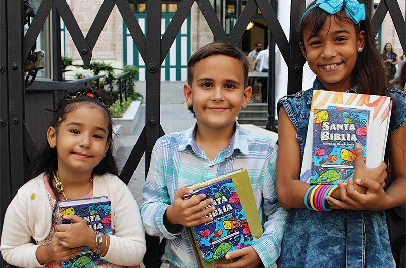 Smiling children with Scripture resources